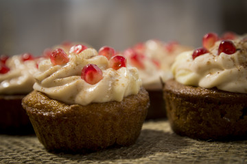 Close-up Tasty chocolate capkake with cheese cream decorated with pieces of pomegranate