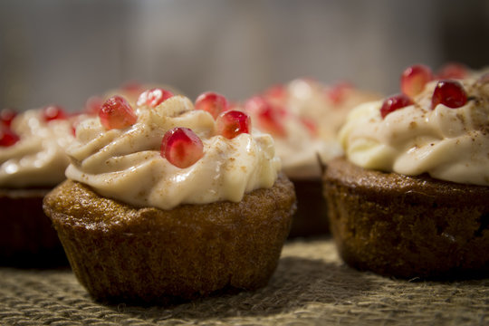 Close-up Tasty chocolate capkake with cheese cream decorated with pieces of pomegranate
