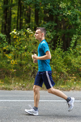 Young boy jogging through forest