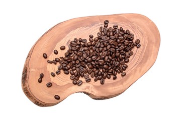 Fried whole coffee beans lie on a cut of an olive tree isolated on a white background