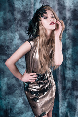 Attractive young woman posing in sequin dress. Studio image