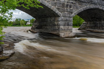 Fototapeta na wymiar Water under the bridge in Pakenham, Ontario - longest five-span stone bridge found on north American continent.
