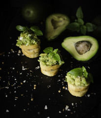 Toasts with pasta from avakado or guacamole and spices on wooden table with fruits, selective focus, concept