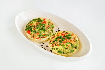 Omelette with tomatoes and herbs. on a white background. Omelet on a white plate.