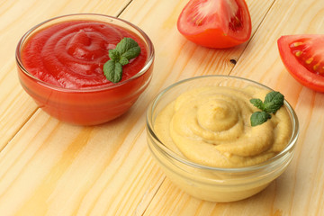 mustard ketchup in glass bowl on wooden background.