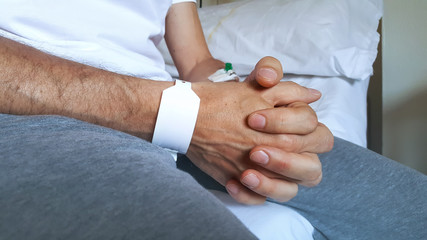 Closeup of the praying hands of a male patient