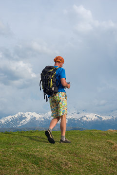Traveler is walking along the ridge. Back view