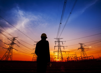 Electricity workers and pylon silhouette