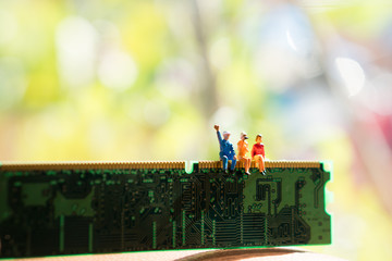 Miniature people sitting on circuit board