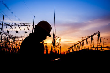 Electricity workers and pylon silhouette