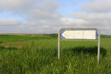 ein leeres Schild in einer dünenlandschaft