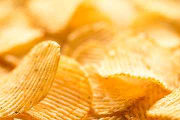 Yellow salted potato chips as background, closeup