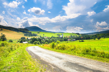 Road, village and mountain summer landscape