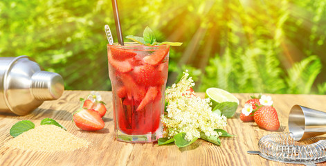 Cocktail mit Erdbeeren, Holunderblütensirup und Limette im Garten