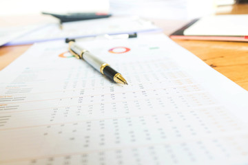 Business and financial reports with pen and calculator on wooden desk