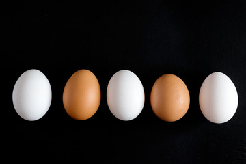 Eggs in the line Chicken eggs White eggs on black background Horizontal photo Eggs background