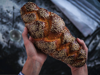 Baker's hands hold fresh bread
