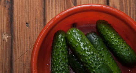 Ripe cucumbers in a red dish,