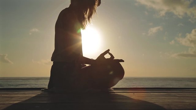 Young woman practicing yoga on the beach.