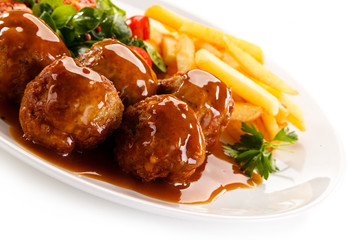 Roasted meatballs, chips and vegetables 