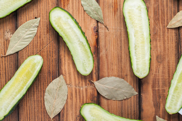 Fresh cucumbers in slit on wooden background.