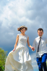Fototapeta na wymiar Young and handsome newlyweds on a walk in the park. Jump into happiness
