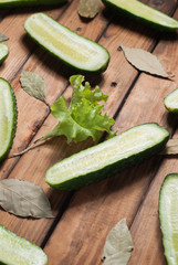 Fresh cucumbers in slit close-up on wooden background.