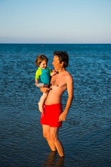 Father and daughter playing together in the sea water