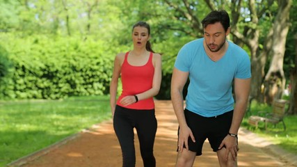 Exhausted man and woman catching breath after jogging, running at the park. Tired couple. close up - Powered by Adobe