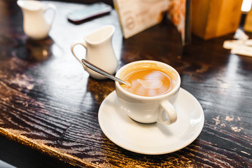 Cup of coffee on a wooden table in cafe