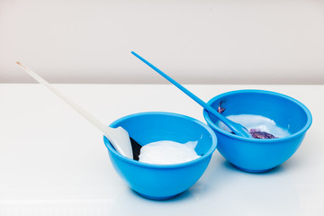 Two plastic bowls with bleach hair dye