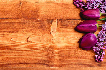 Fototapeta premium Decoration made of purple tulip and lilac flowers on wood