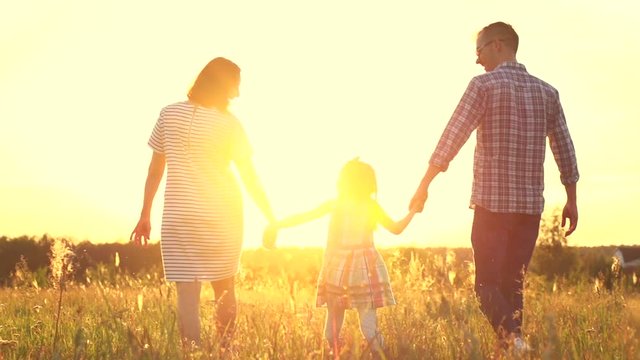 Happy young family with child walking on summer field. Slow motion. 4K UHD video 3840X2160