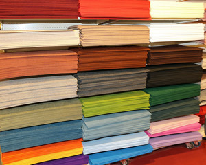 Shelf full of fabrics for sale at the fair for decoration and le