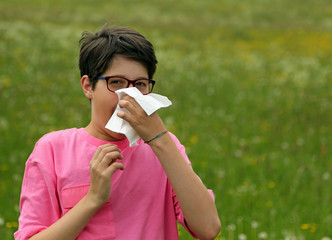 Young boy with allergy blows his nose