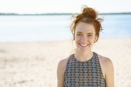 young woman with a lovely warm smile on the beach