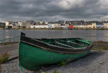 Fototapeta na wymiar old fishing boat and houses in the distance of the Claddagh, Galway