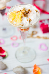 Ice cream dessert on table with hearts, ribbons and cloves.