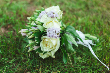 Obraz na płótnie Canvas Beautiful bridal bouquet of the bride on the green grass