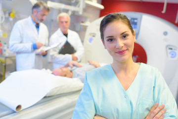 Fototapeta premium young female doctor standing next to a cat-scan machinery