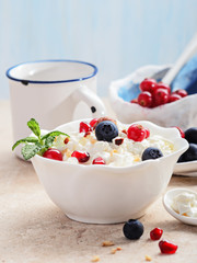 Cottage cheese with berries on light background.