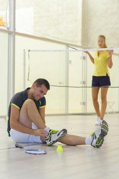 couple playing badminton indoors
