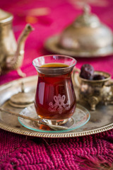 Tea set in oriental style in pear shaped glass with vintage kettle and dates fruit