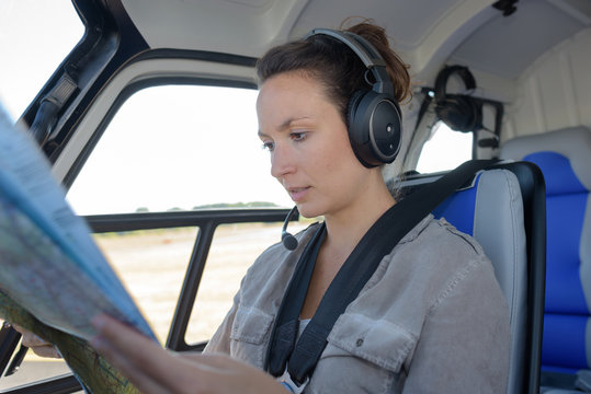 young woman helicopter pilot reading map