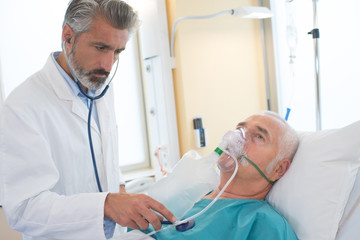 senior patient making inhalation with nebuliser in exam room