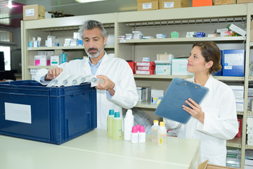 Obraz premium male and female pharmacists maintaining checklist at counter in pharmacy