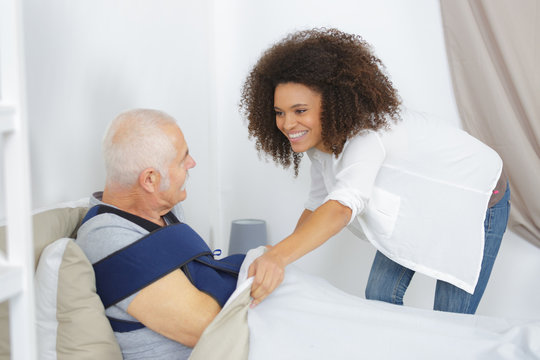 woman taking care of elderly man in nursing home