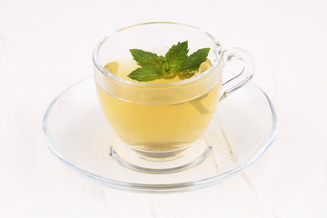 Cup with green tea on white background with mint leaves