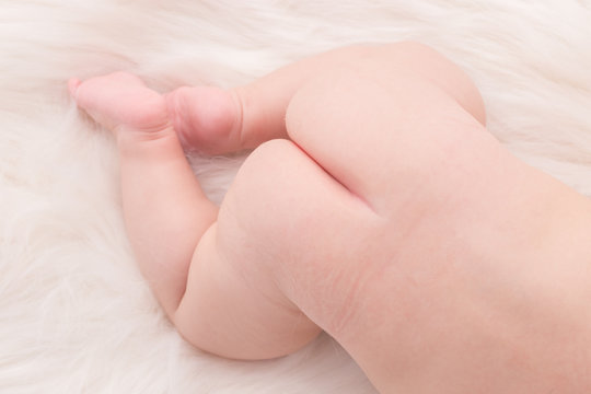 Close up baby bottom lying on white cloth background