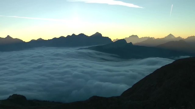 Die Sonne geht &uuml;ber einem flie&szlig;enden Wolkenmeer und den  Ampezzaner Dolomiten auf Blick vom Rifugio Kostner in der Sella Gruppe, S&uuml;dtirol, Italien, Zeitraffer